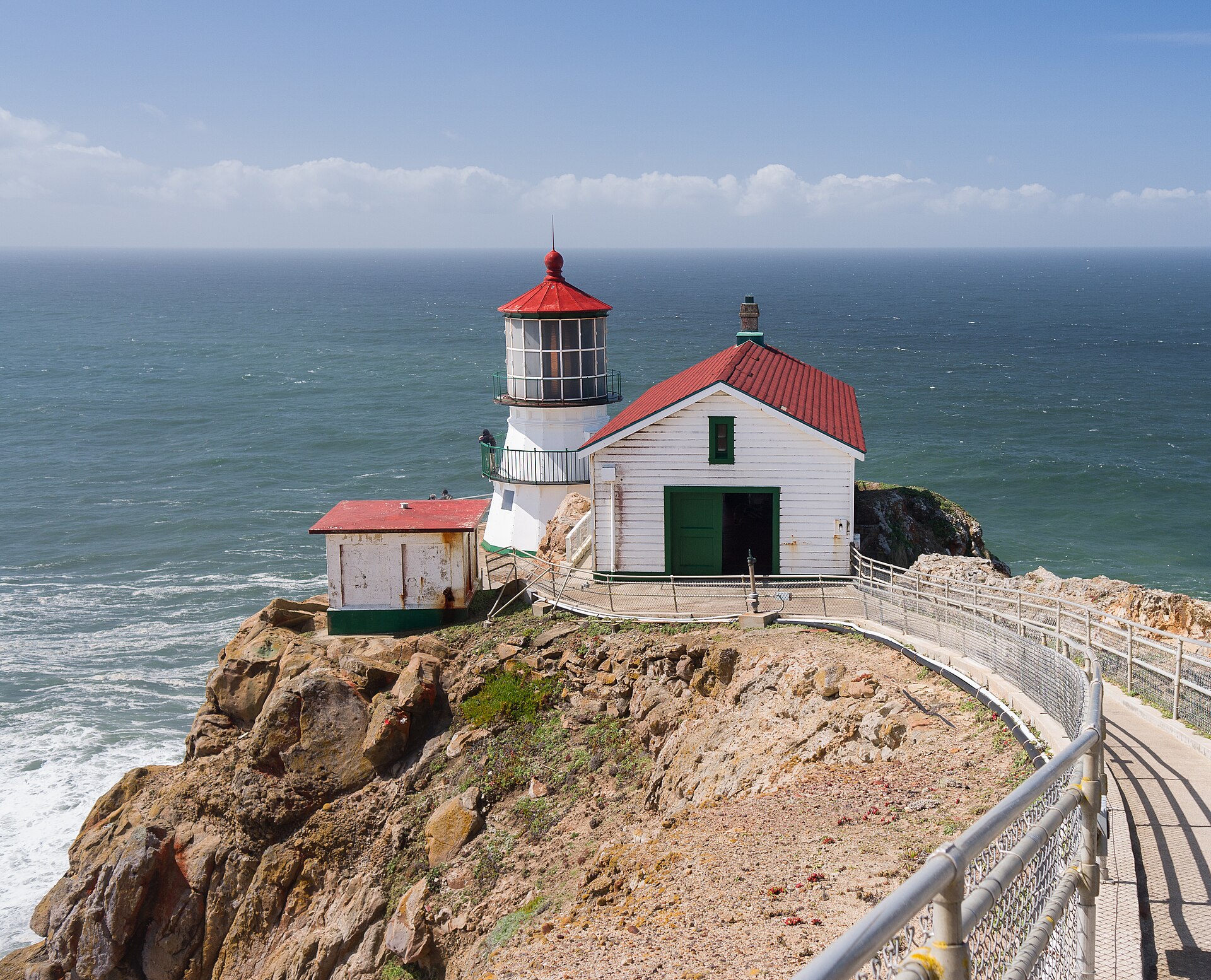 Point Reyes Lighthouse on the outer peninsula, white structure against gray sky and Pacific Ocean